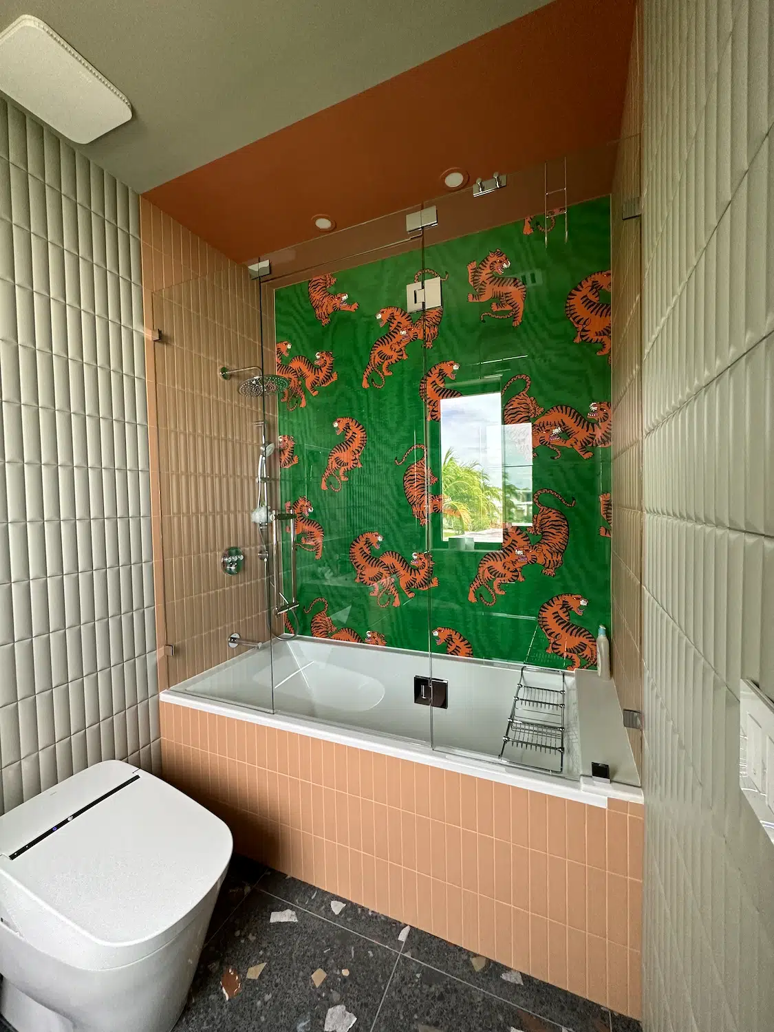 Custom kids bathroom remodel in Miami featuring decorative tiger accent tile wall, porcelain tile installation, frameless glass enclosure, and modern fixtures.