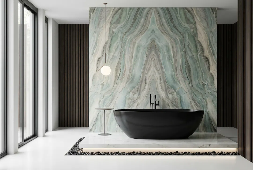 Luxury bathroom remodel in Miami featuring a bookmatched stone slab feature wall, black freestanding bathtub, floating platform, and premium tile installation.
