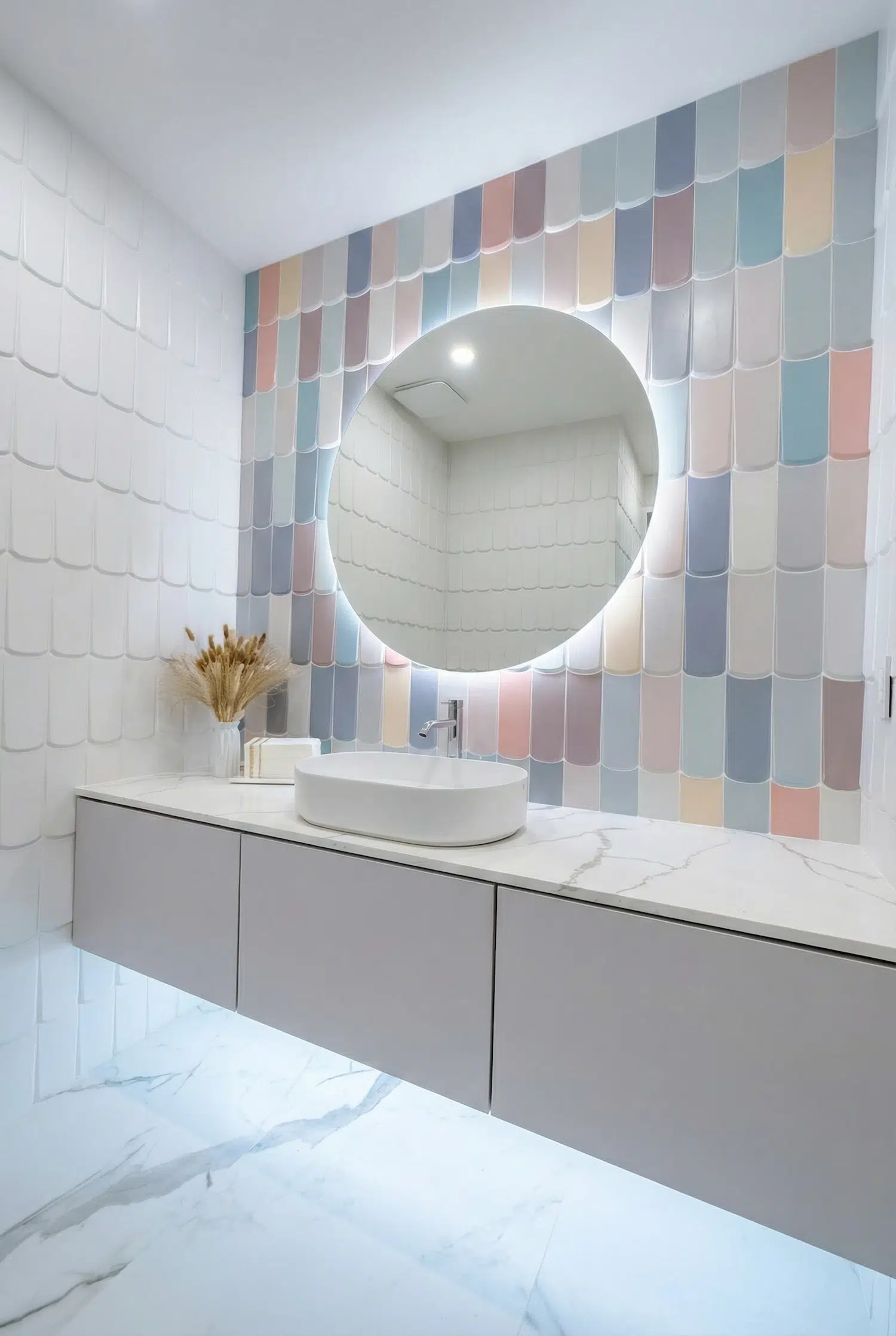 Luxury powder room remodel with pastel fish scale tile feature wall, floating vanity, round LED mirror, large-format porcelain floor tile, and custom tile installation in Miami.