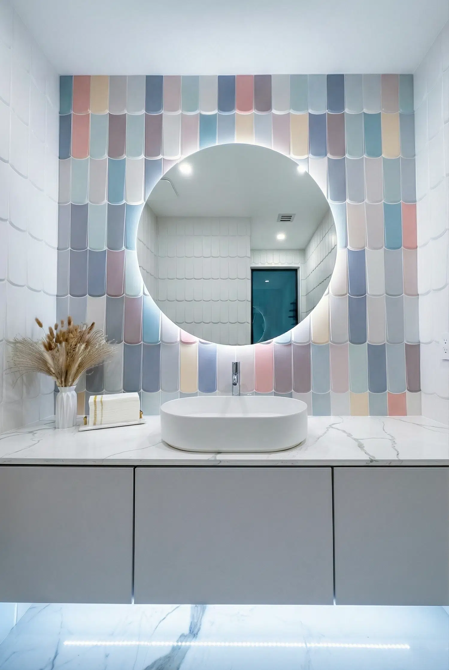 Modern powder room vanity with pastel fish scale tile accent wall, round LED backlit mirror, floating vanity, and quartz countertop in Miami luxury home.