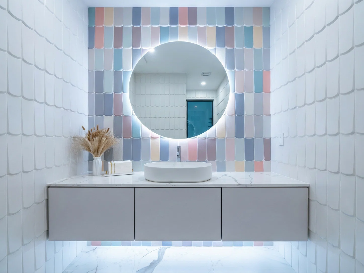 Remodeled powder room in Weston, FL, with pastel accent tile, a floating gray vanity, white vessel sink, and backlit round mirror.