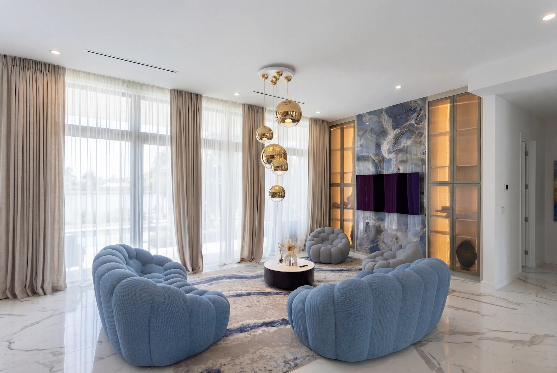 Luxury living room with marble-look porcelain slab feature wall, wood slat ceiling, and modern blue armchairs in Fort Lauderdale home