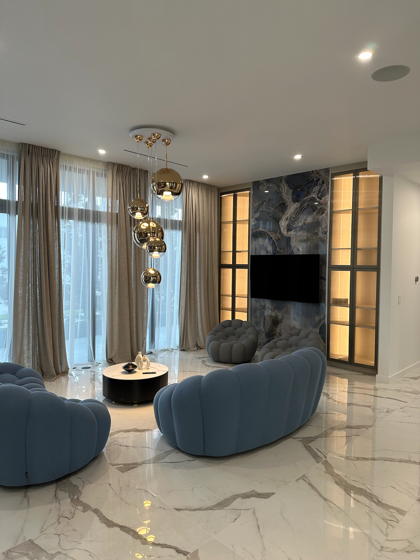 Custom TV feature wall with porcelain slab panels and integrated cabinetry in contemporary living room