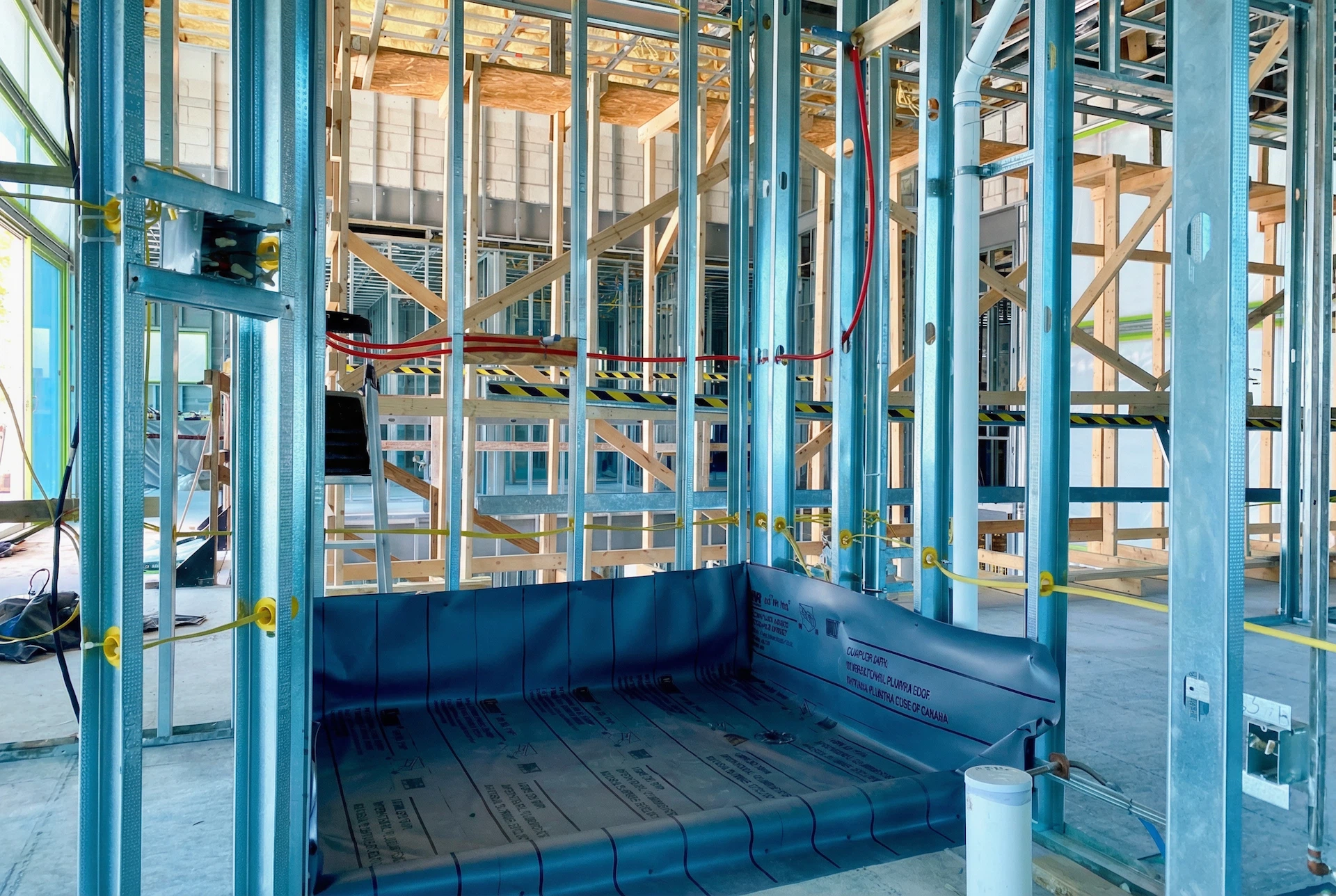 Full shower waterproofing system installed across pan, walls, and penetrations prior to tile installation