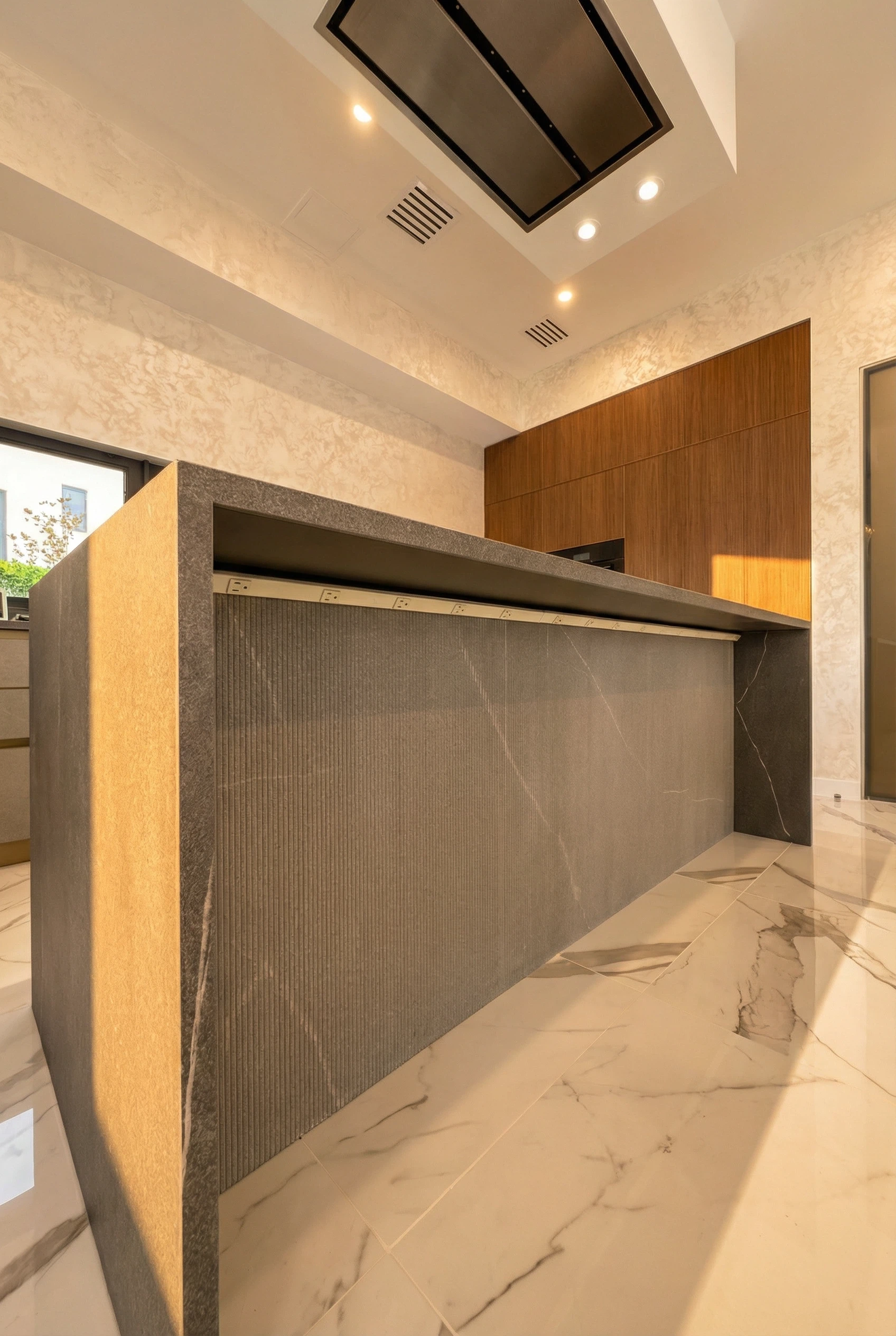 Large-format porcelain slab wrapped kitchen island with mitered edges and seamless fabrication details.