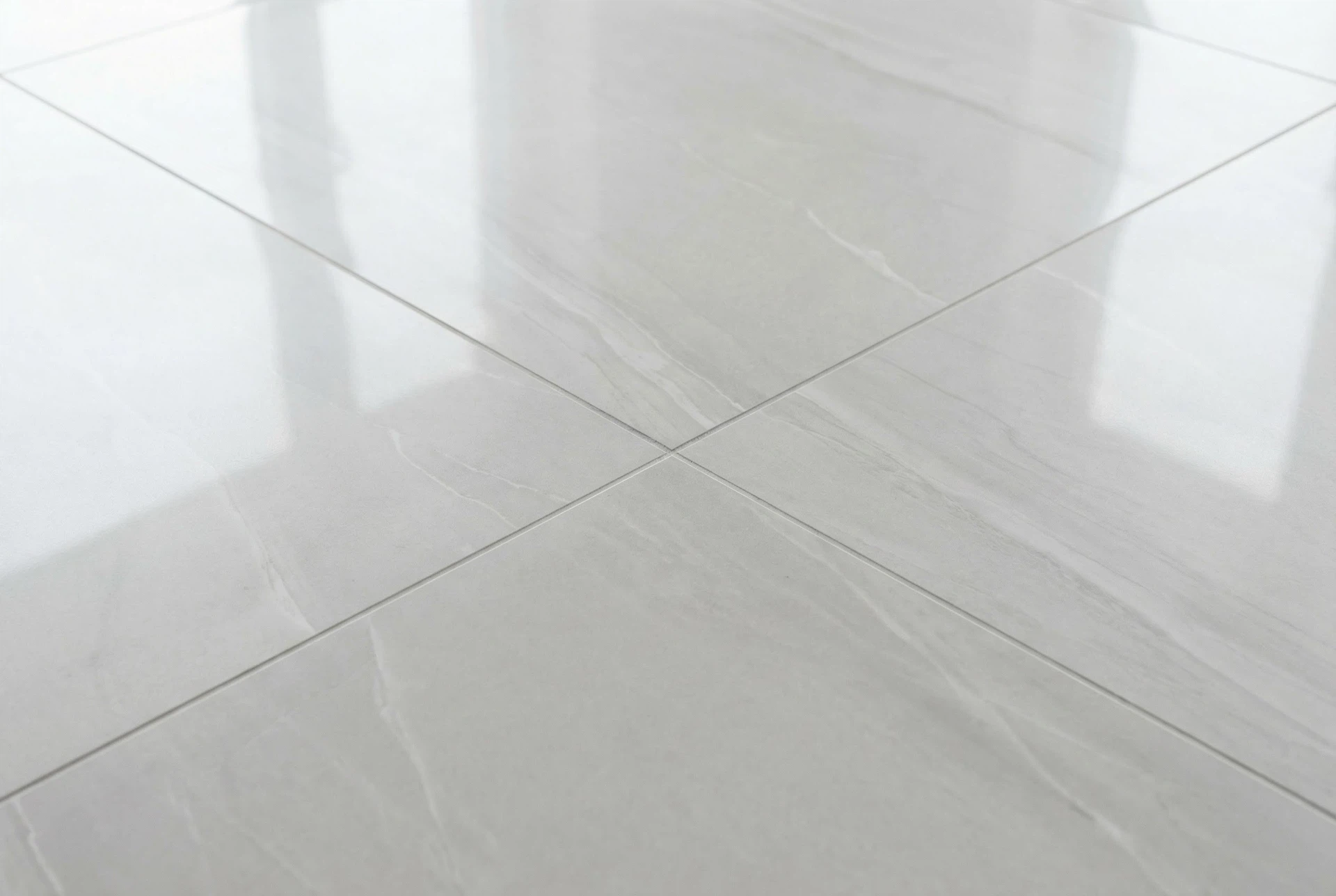 Close-up of large-format floor tile alignment with tight grout lines and smooth level finish