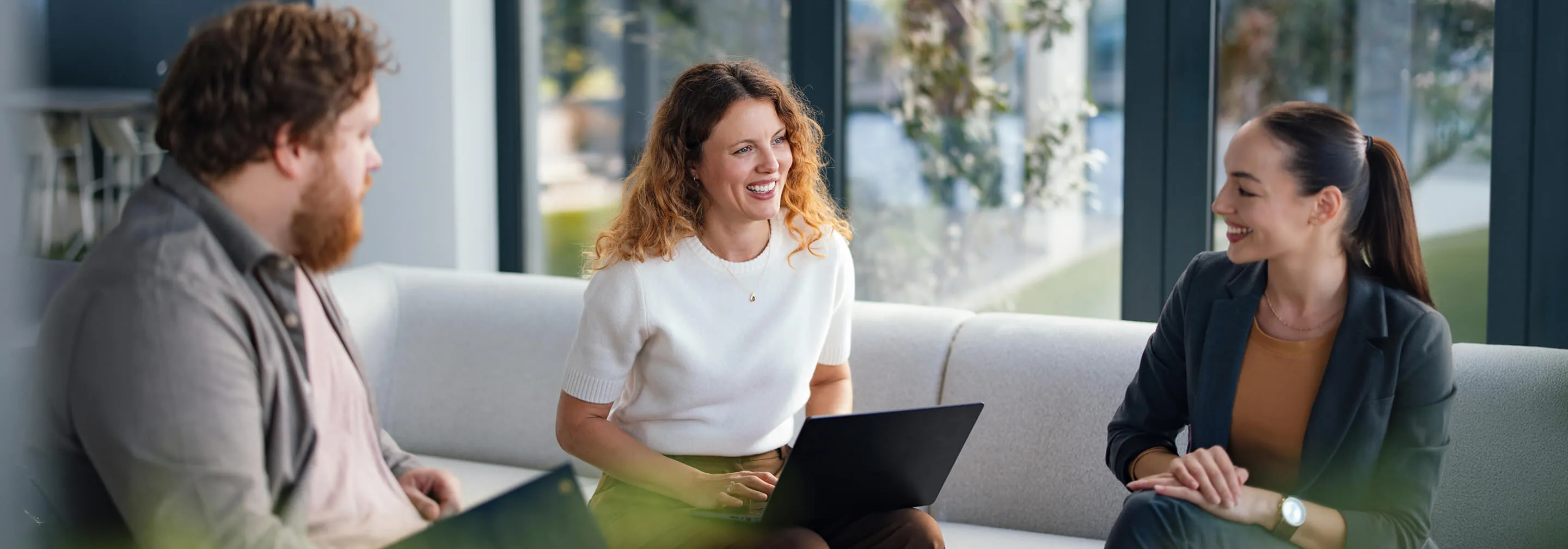 Three team members collaborating in a bright modern office