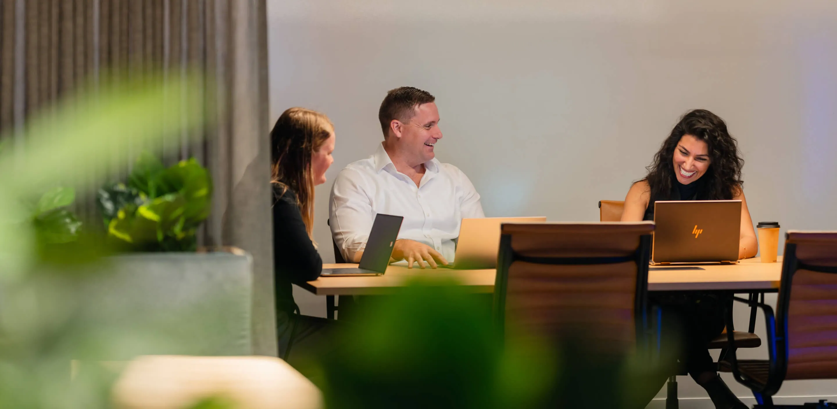 Collaborative workspace with team members using laptops and digital tools