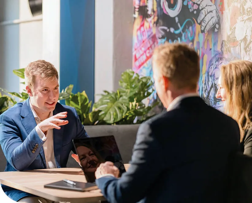 Team members collaborating in a modern office with colourful wall art