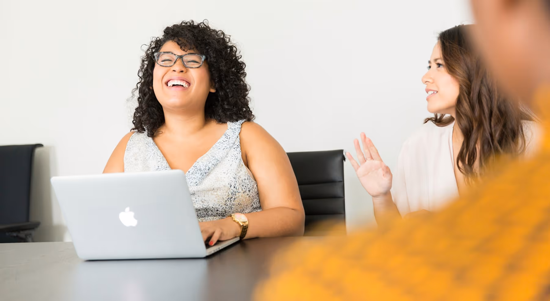 woman laughing at computer screen in office