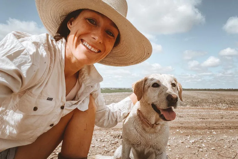 A women who take a selfie of her with her dog in a field