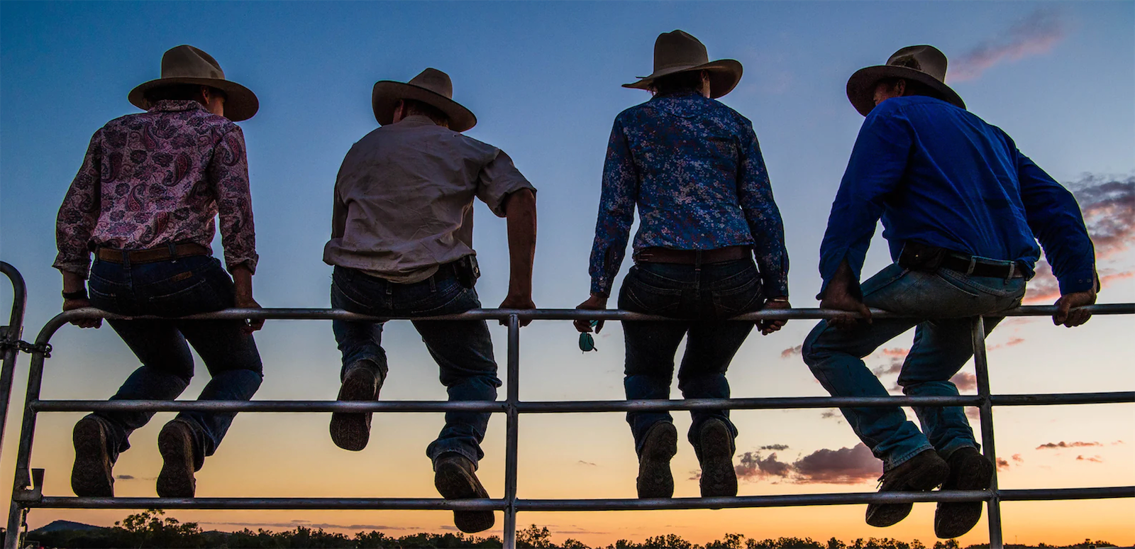 Farmers sitting on a gate at sunset in grain growing New South Wales