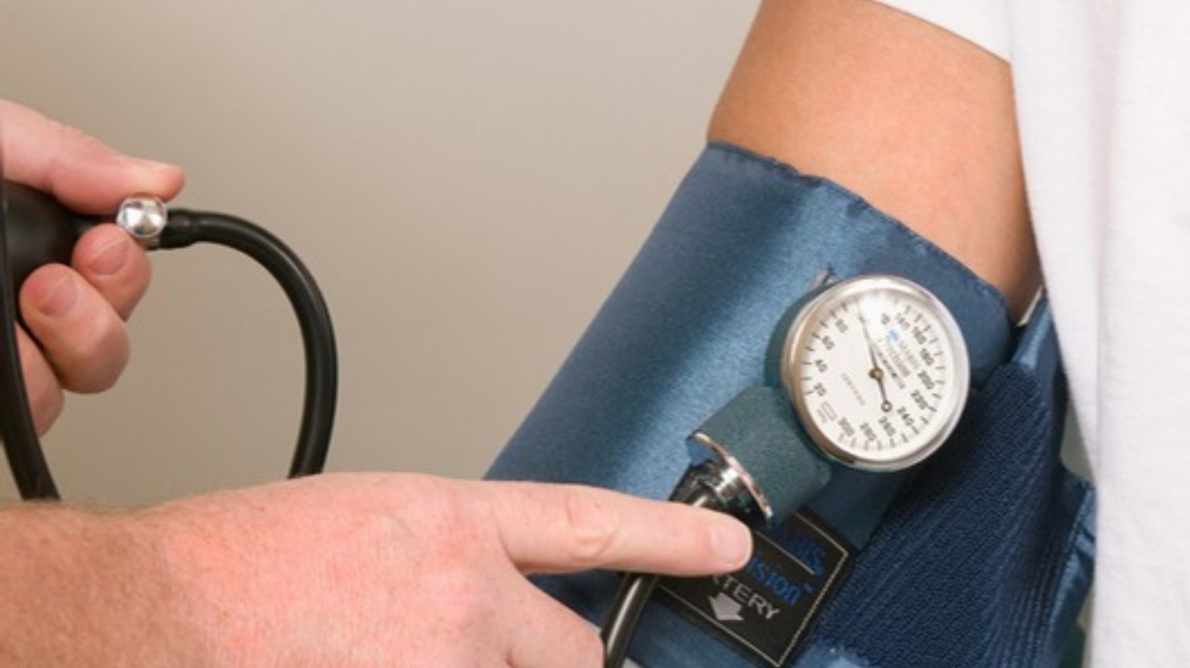 Clinician taking a patient's blood pressure with a cuff during a health check