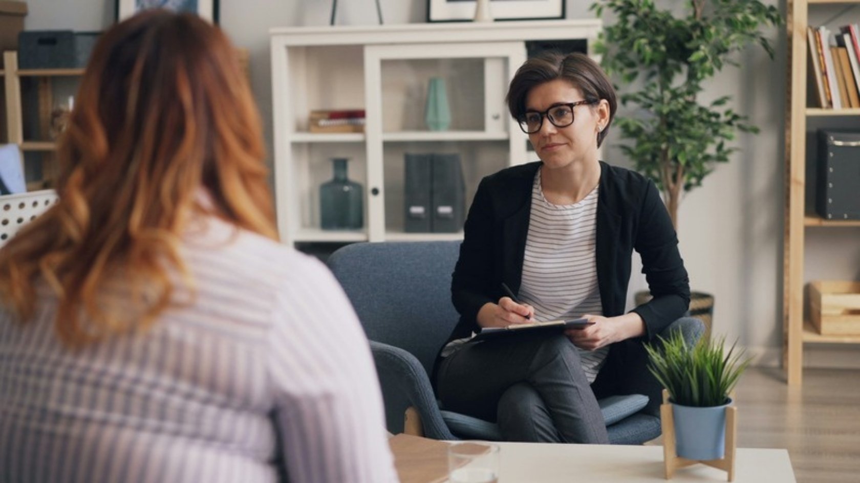 Female clinician listening to a woman during a calm, private consultation