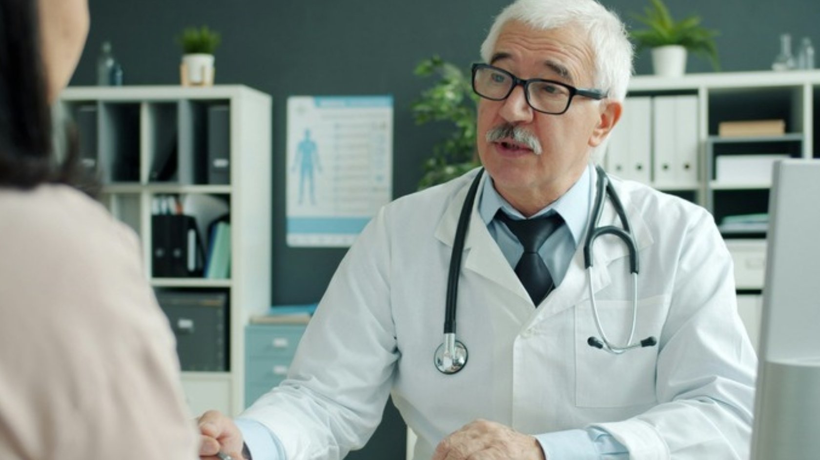 Doctor talking with a woman during a consultation in a calm clinic room