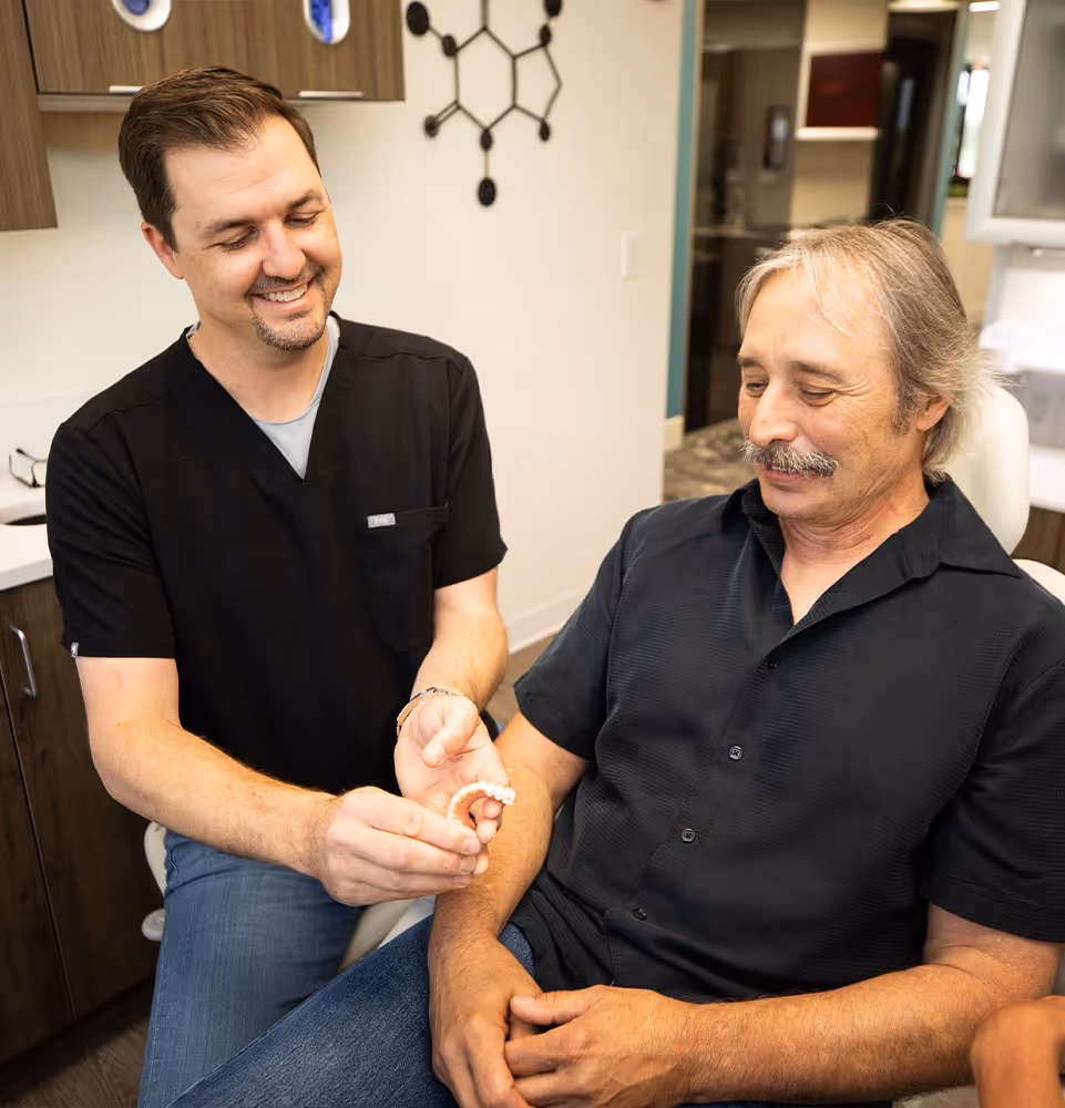 A man sitting next to a man in a dentist chair.