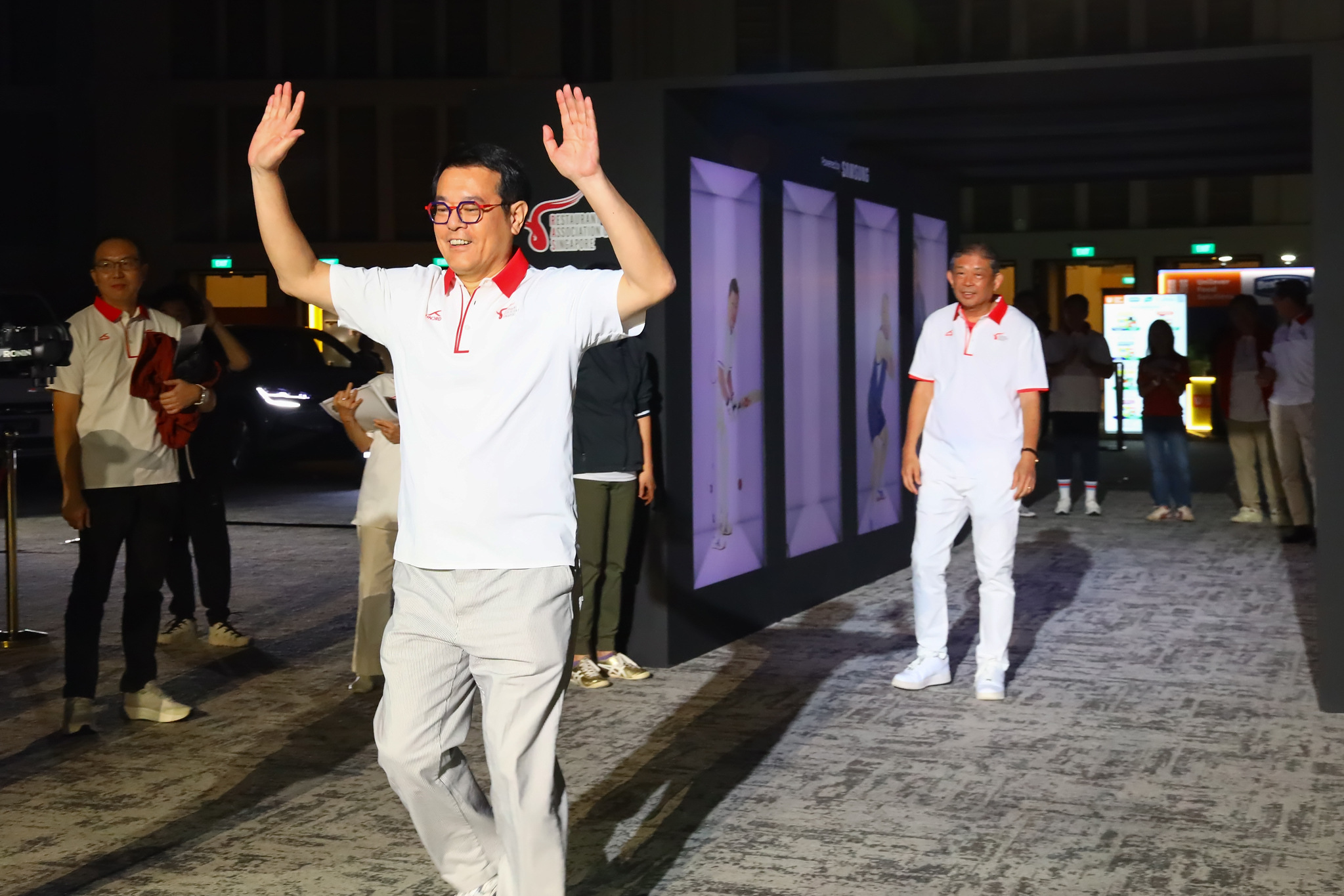 A committee member waves to the crowd on the walk in