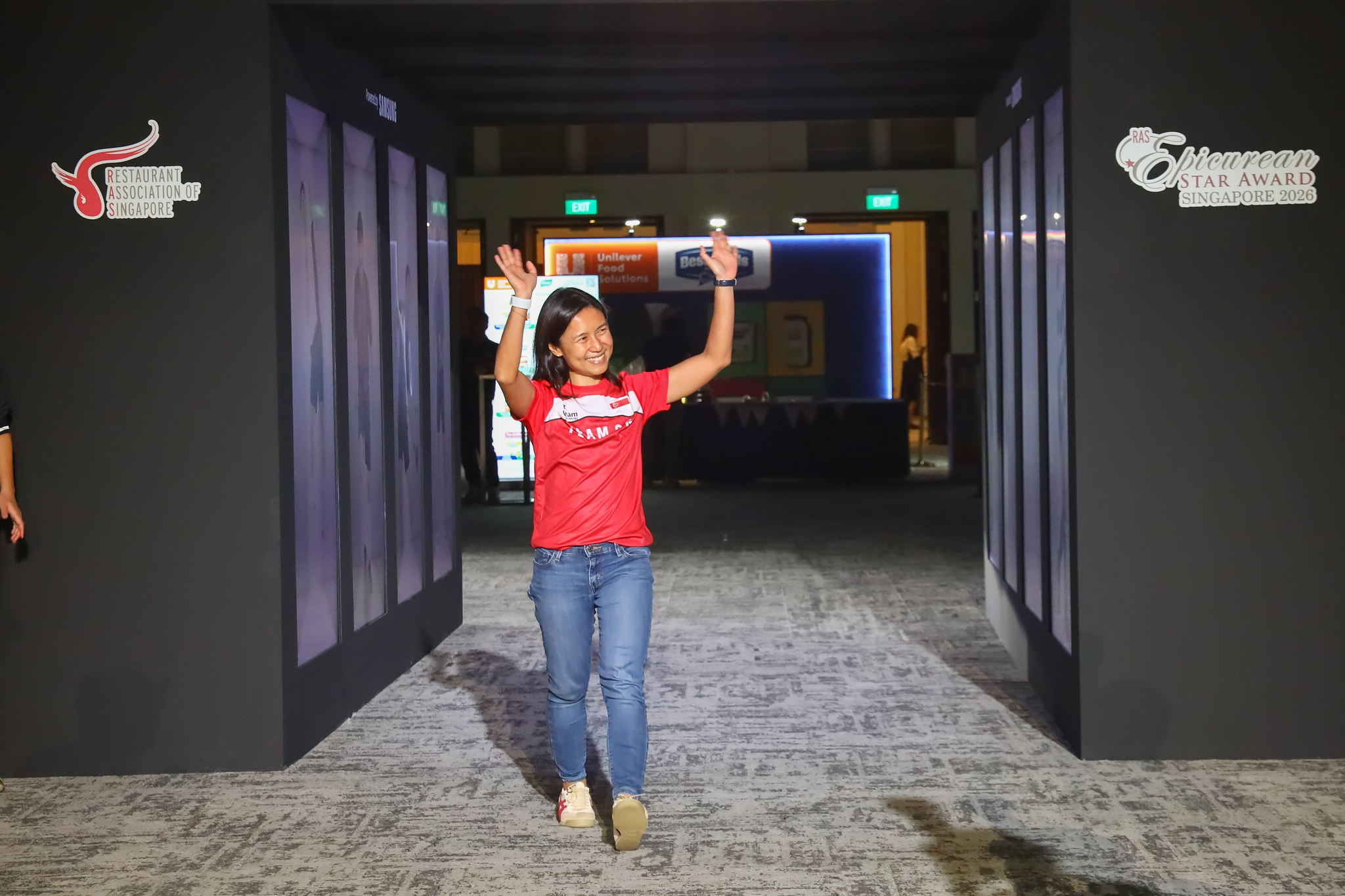 A Team SG athlete waves as she walks in