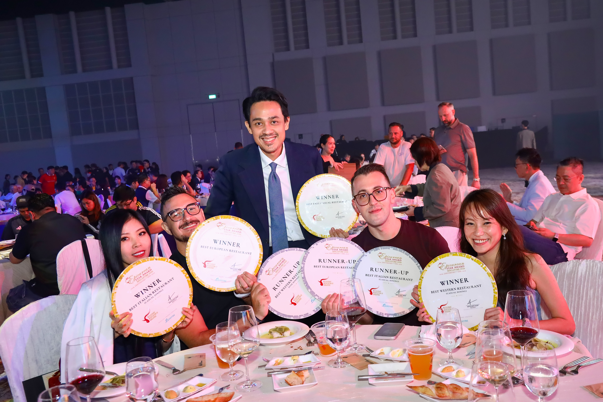 Winners hold up their awards at the table