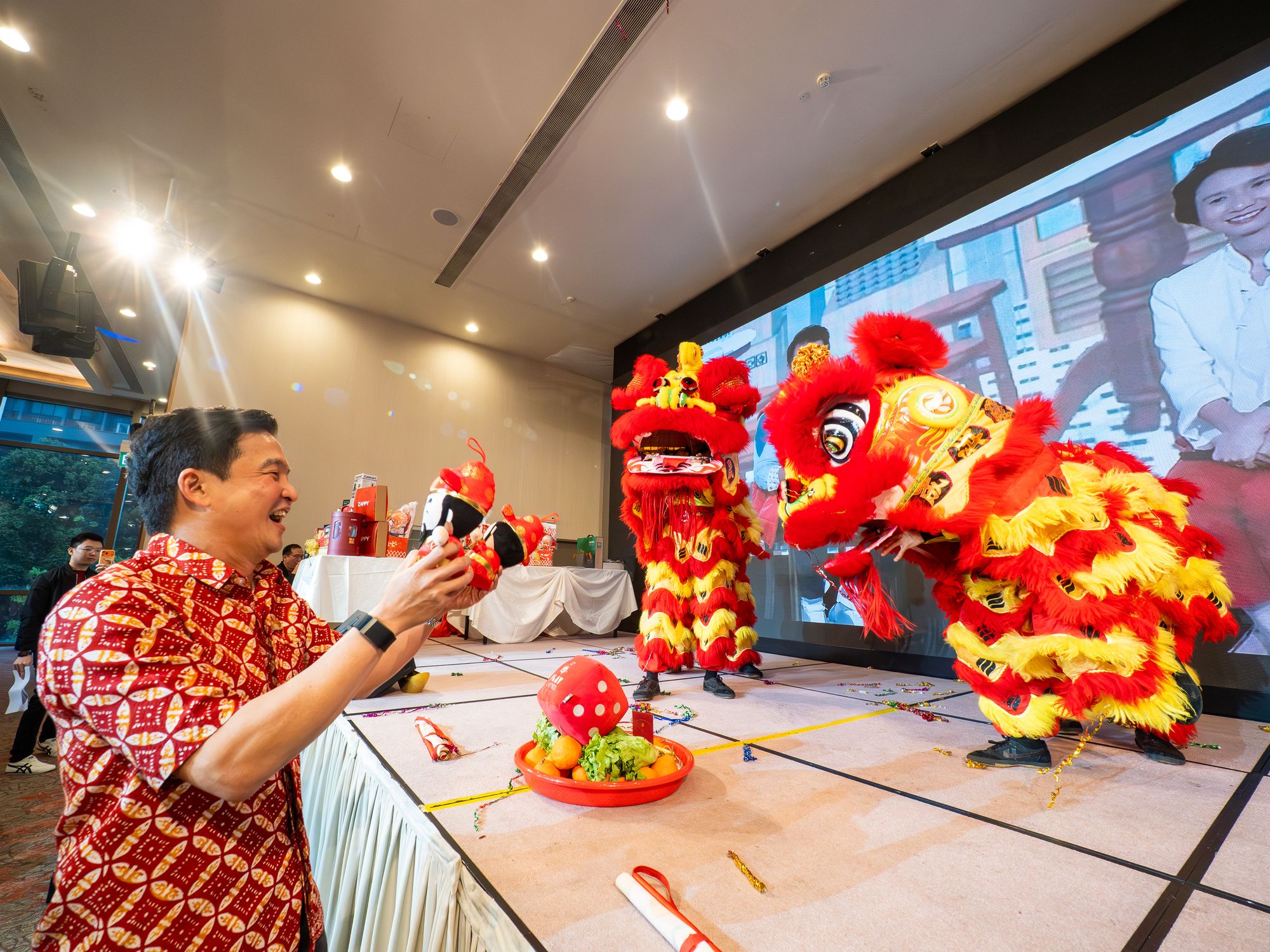 A guest feeds the lion during the lion dance