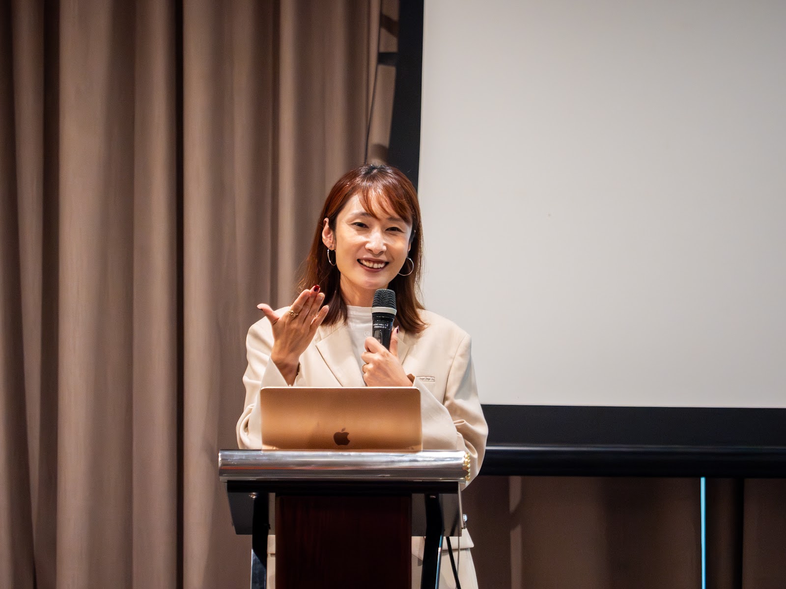 A speaker presenting from the lectern at Lifelong Learning Institute
