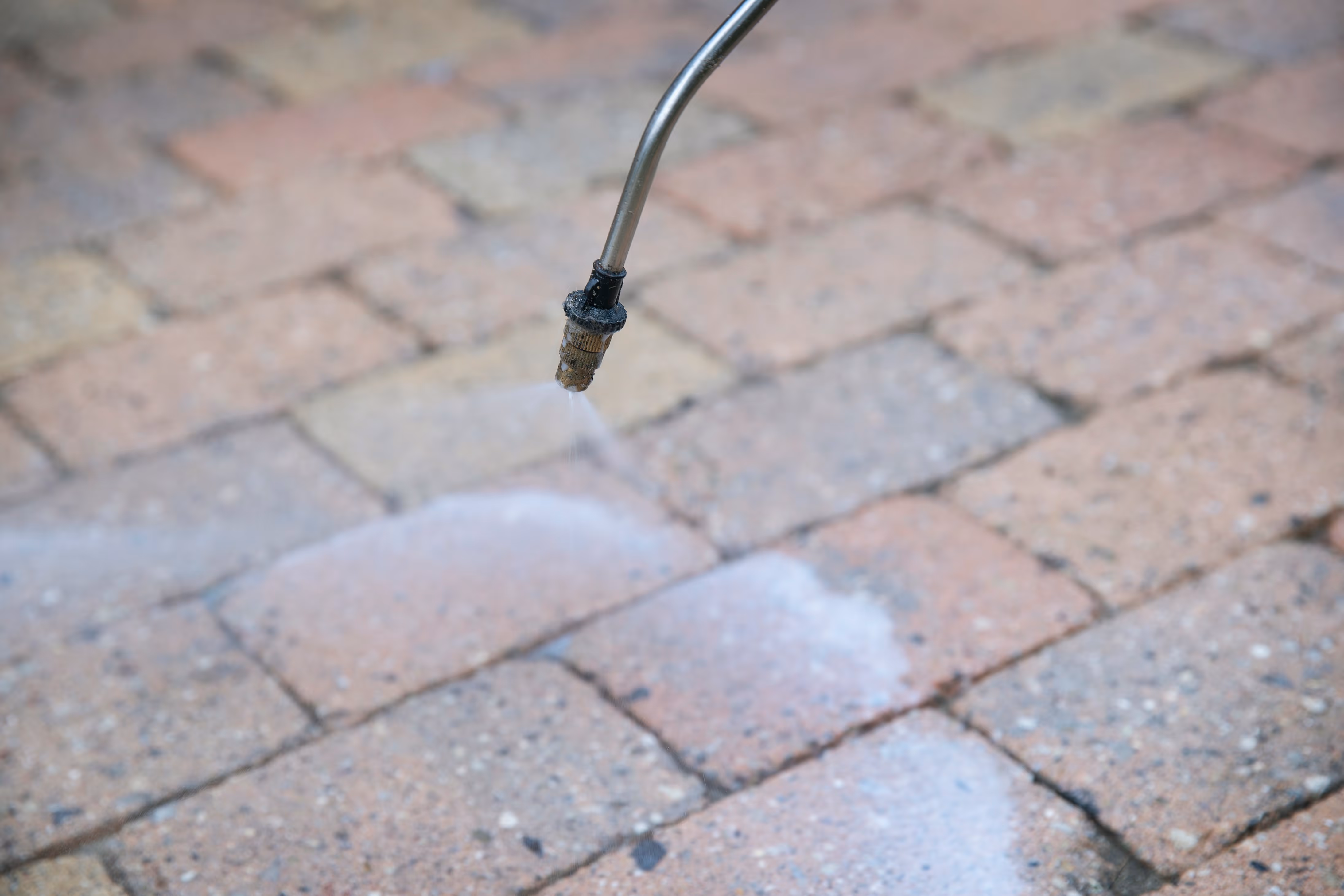 Dyse, der sprøjter vand på brosten til rengøring.