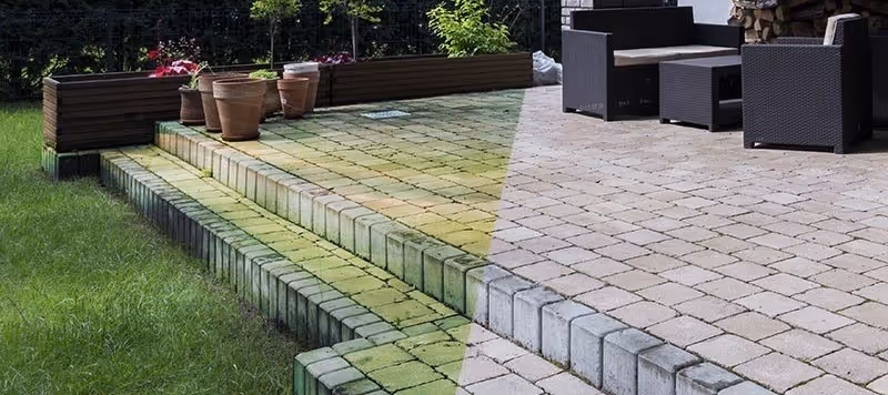 Terrasse med trin bygget af fliser, hvor venstre side er dækket af alger, og højre side er renset og lysere.