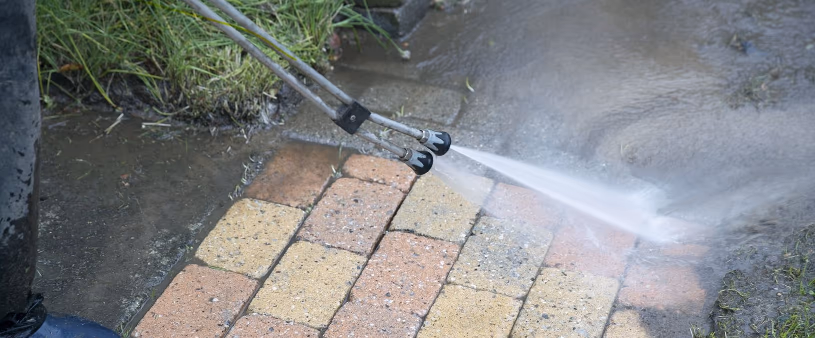 To dyser sprøjter højtryksvand på mursten for at rense fugt og snavs af.