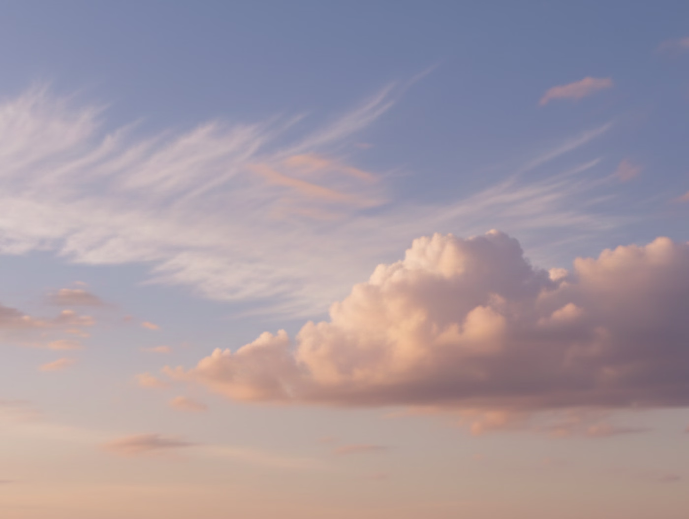 Cielo al atardecer con nubes esponjosas y delgadas iluminadas por la luz dorada.