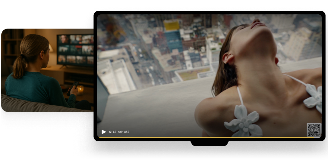 View of a woman watching a large screen TV from behind, holding a remote control while sitting on a couch, with the TV showing a close-up scene of a woman in a white top leaning back with a cityscape in the background.
