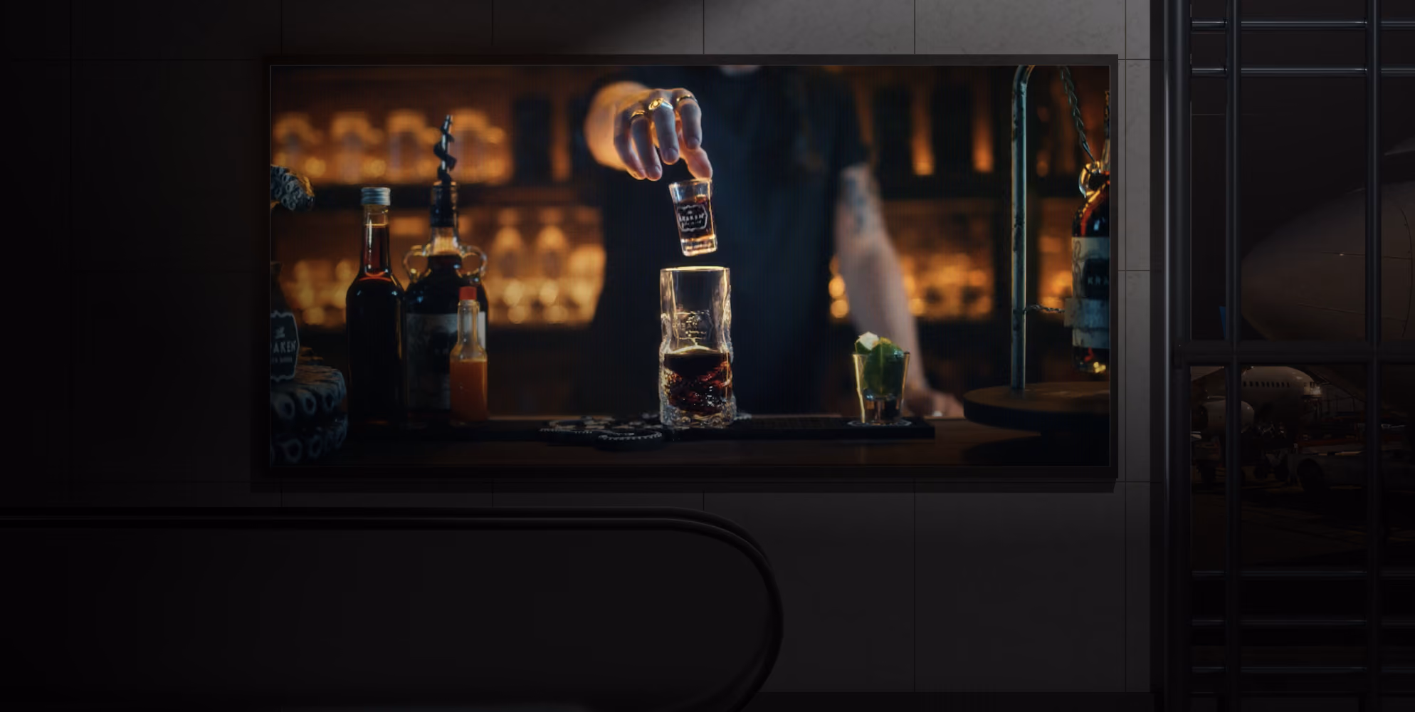 A hand drops a shot glass with whiskey into a larger glass with whiskey on a bar counter.