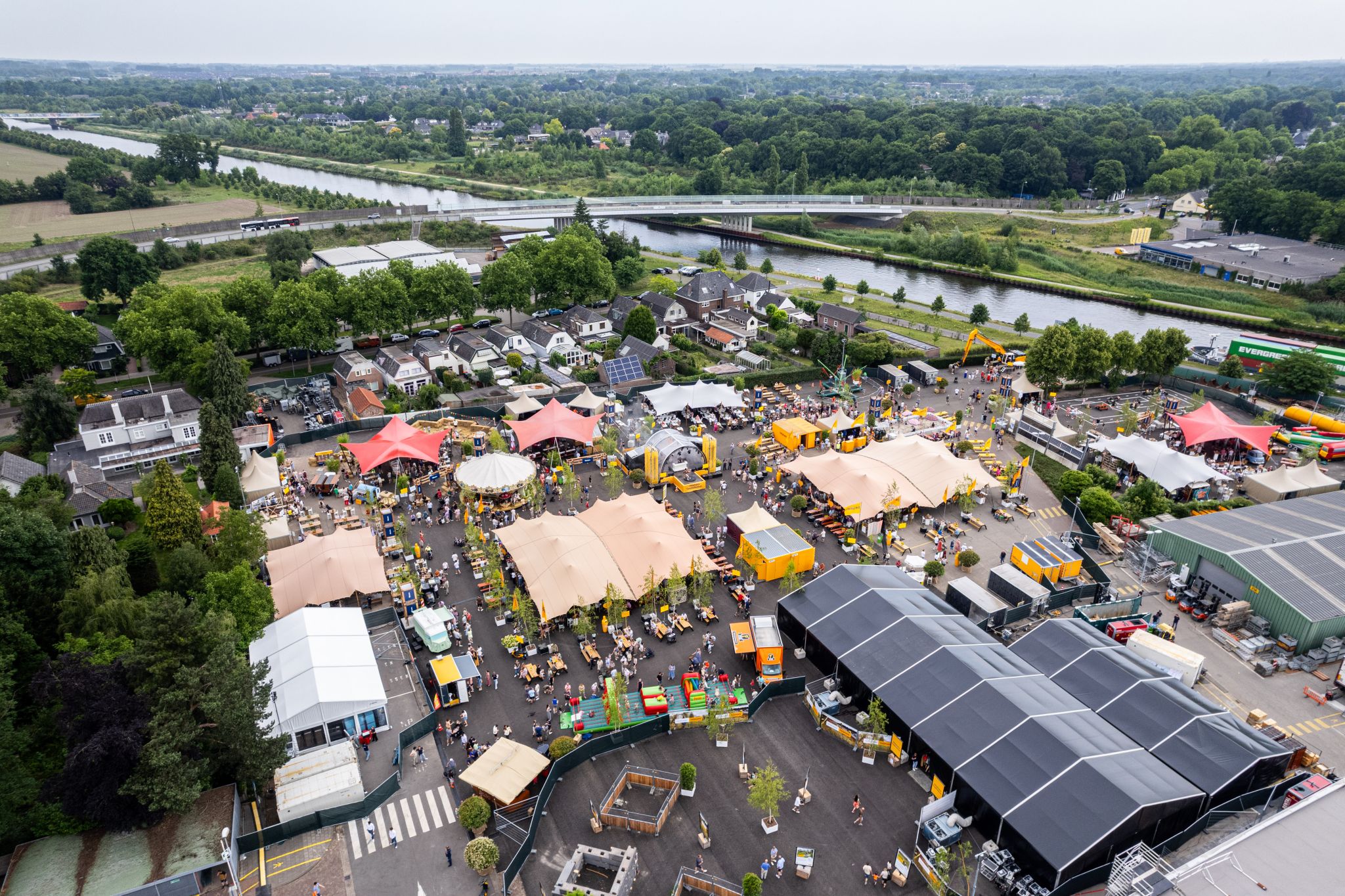 Drone-overzicht van een groot evenemententerrein met tenten en activiteiten
