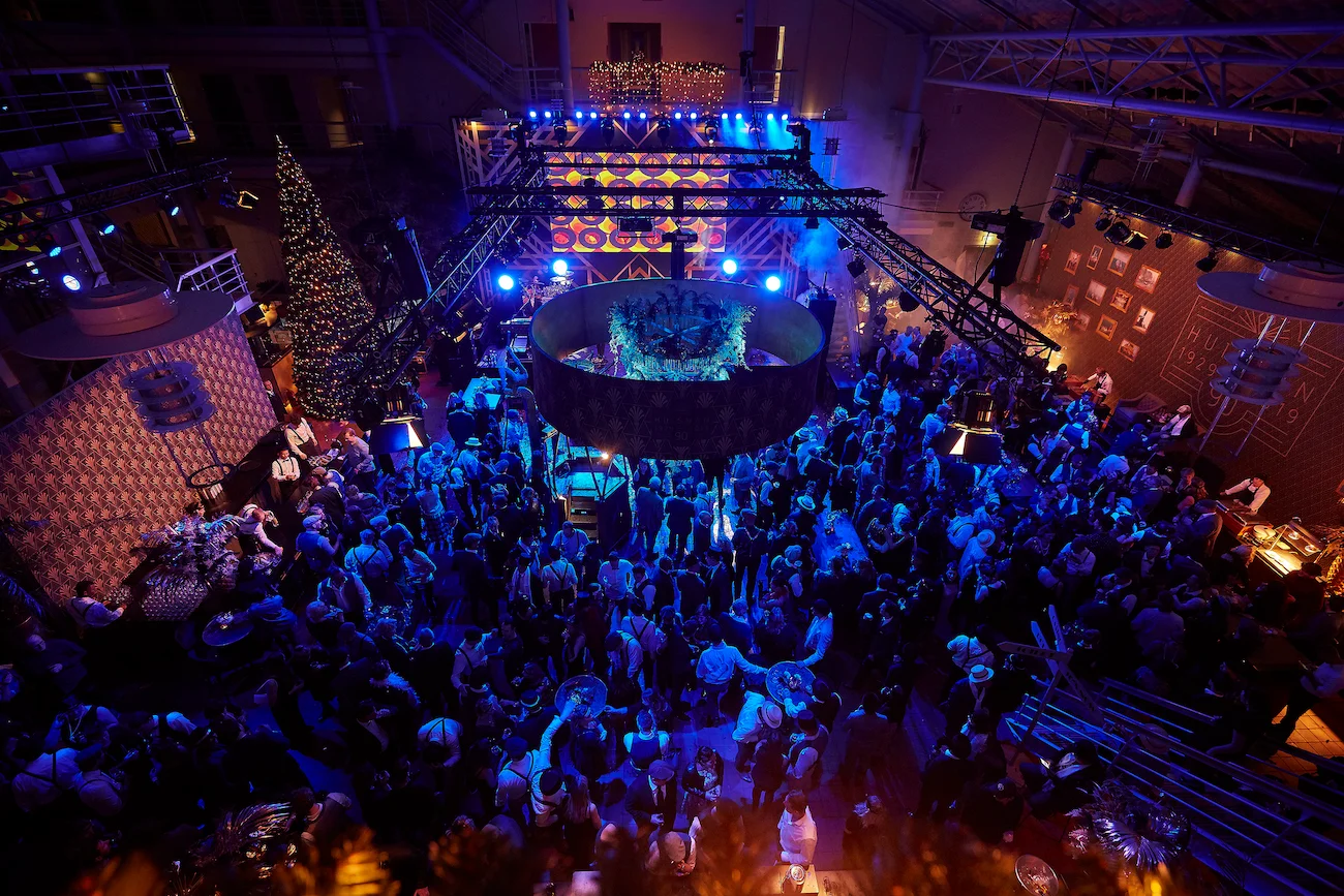 Vogelvlucht van een grote feestzaal met blauw-gouden verlichting bij een jubileum