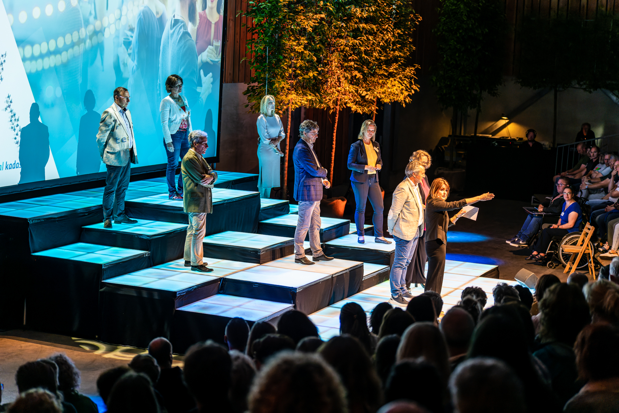 Plenaire sessie met sprekers op podium tijdens een zakelijk congres