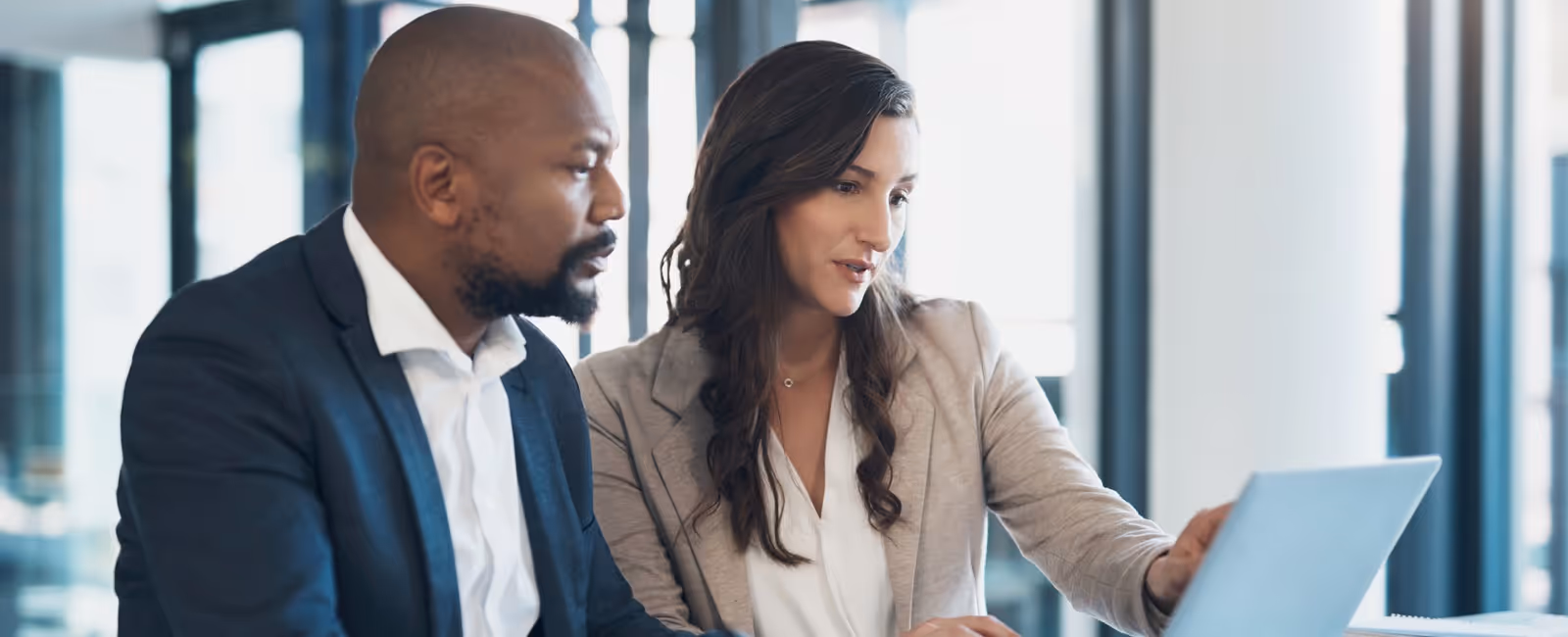 Two business professionals reviewing portfolio planning information together on a unified platform