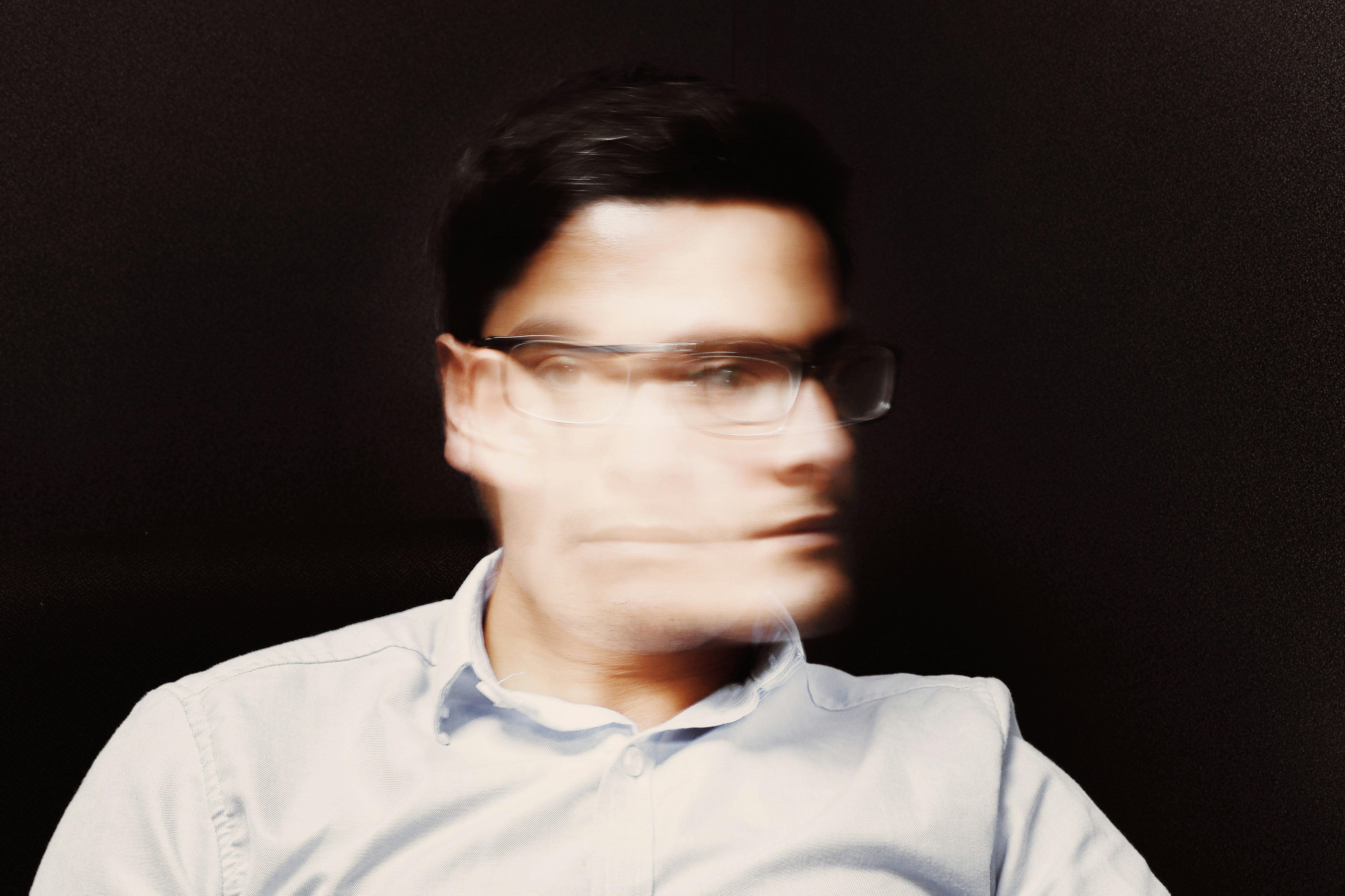 Porträt eines Mannes mit Brille und Bewegungsunschärfe im Gesicht.