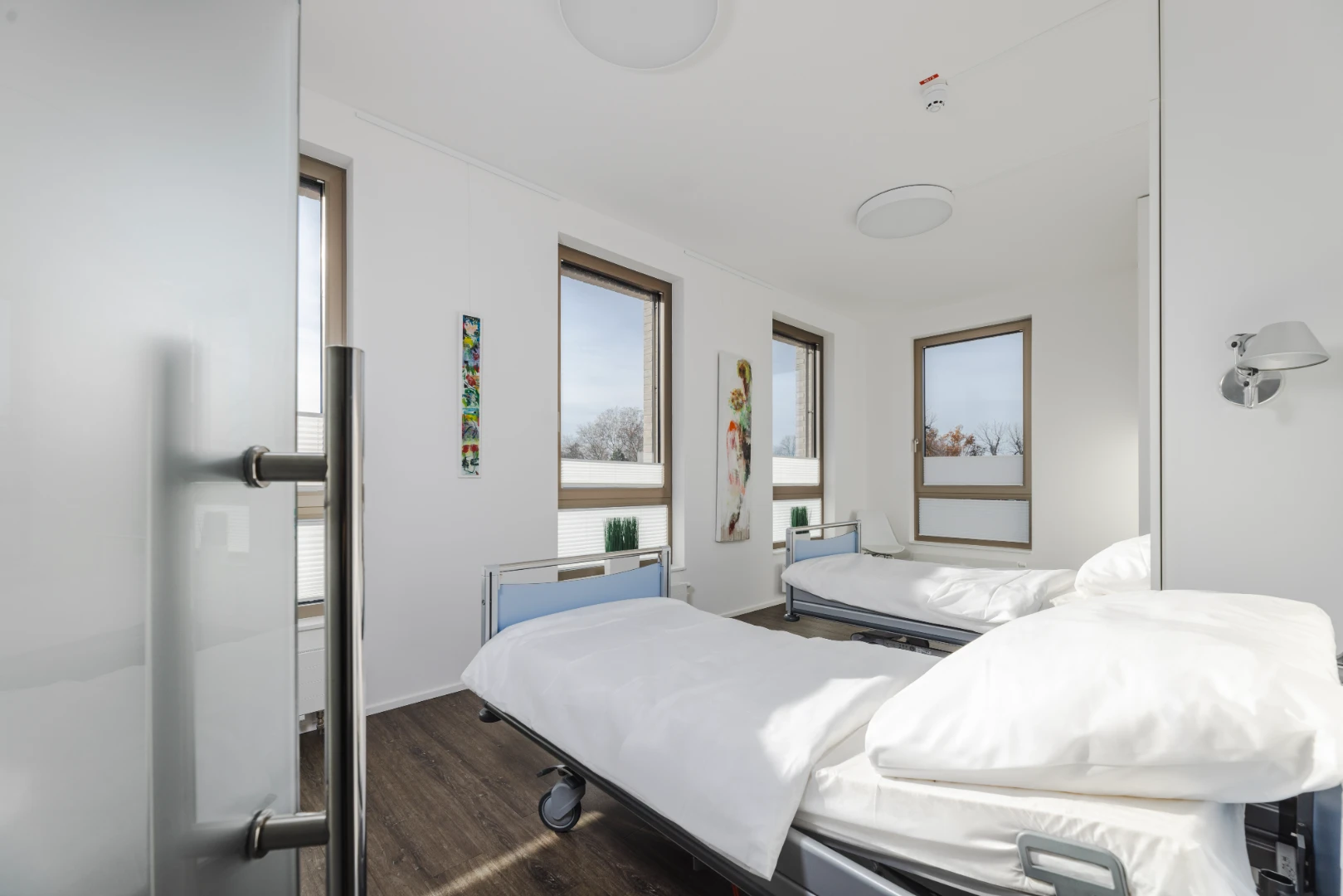Helles Patientenzimmer der Penthouse-Klinik von Schwaben Aesthetic mit zwei Betten und großen Fenstern.