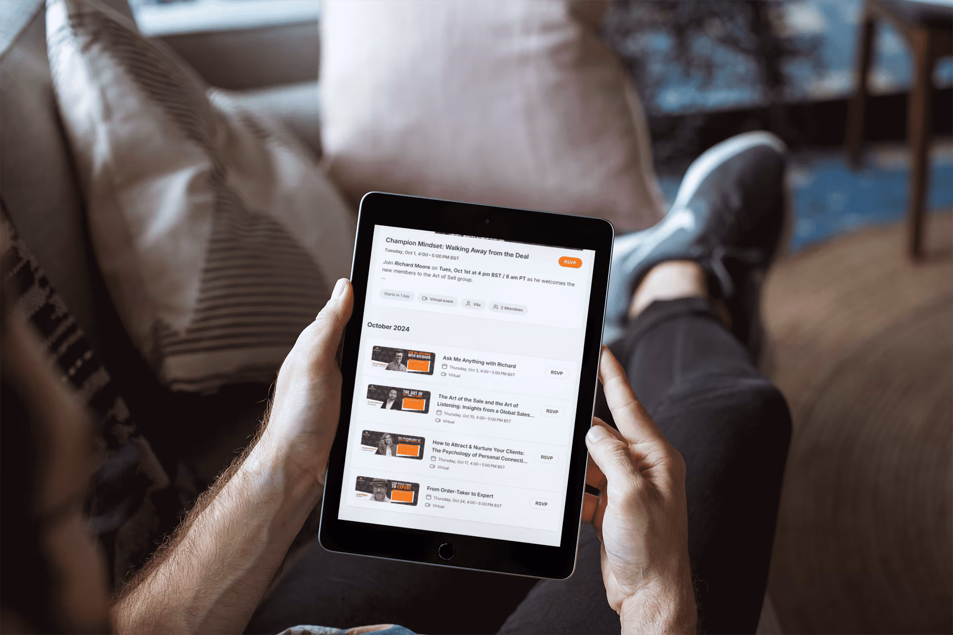 Person holding an iPad showing a virtual event schedule with multiple sessions to RSVP for in October 2024.