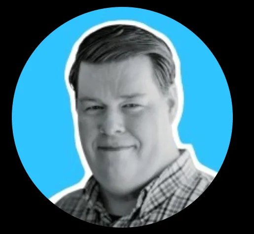 Black and white headshot of a man smiling, against a blue circular background.