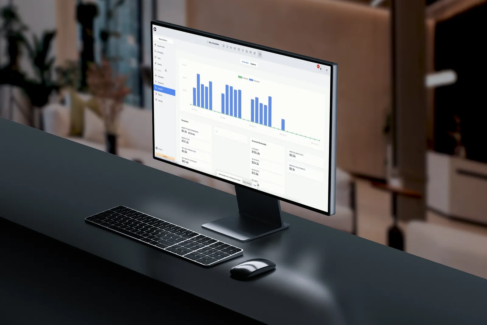 Curved computer monitor on desk showing a blue bar chart and financial data dashboard, with wireless keyboard and mouse in a modern office setting.
