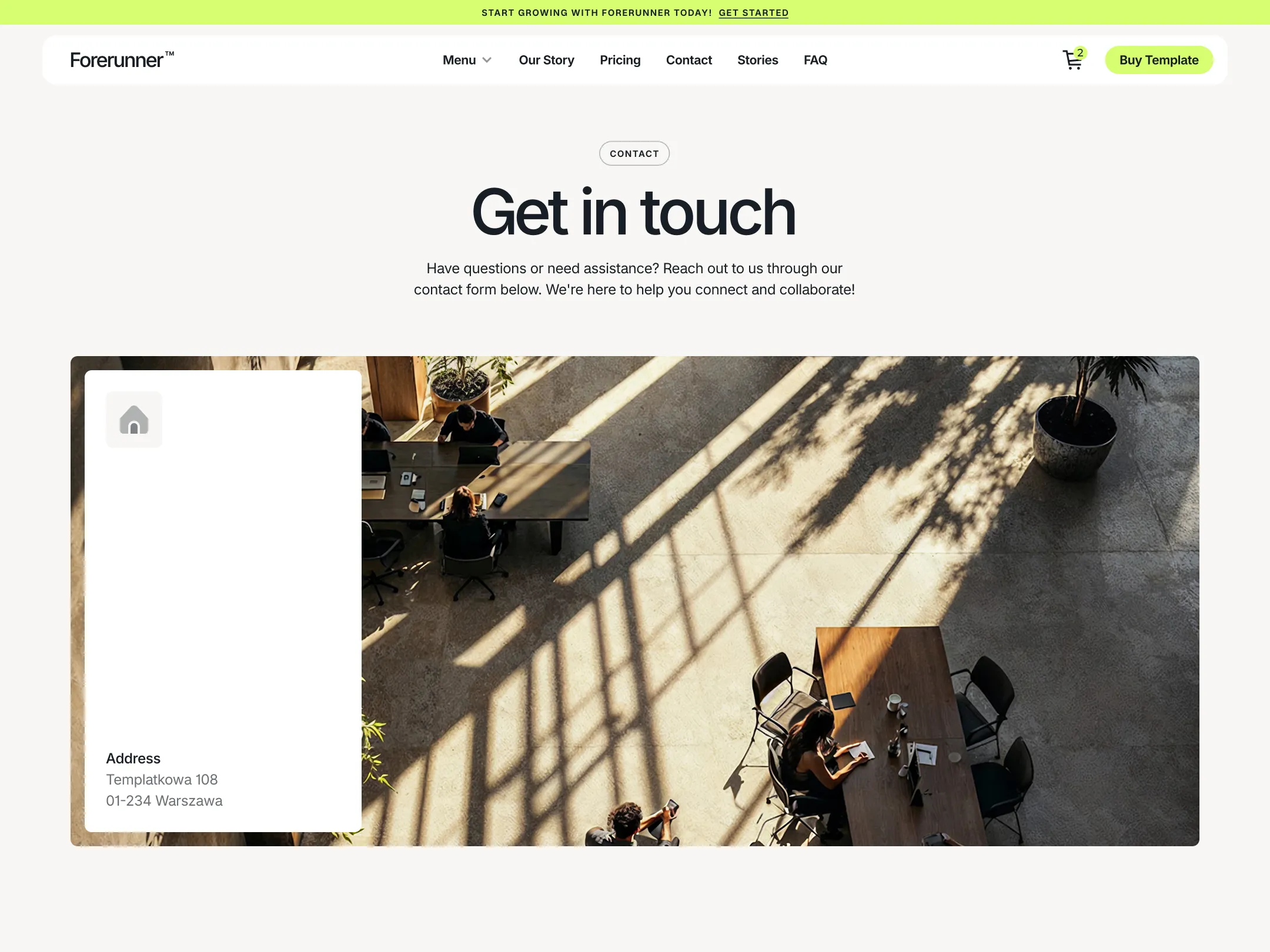 Aerial view of people working at tables in a sunlit office space with shadows from large windows.