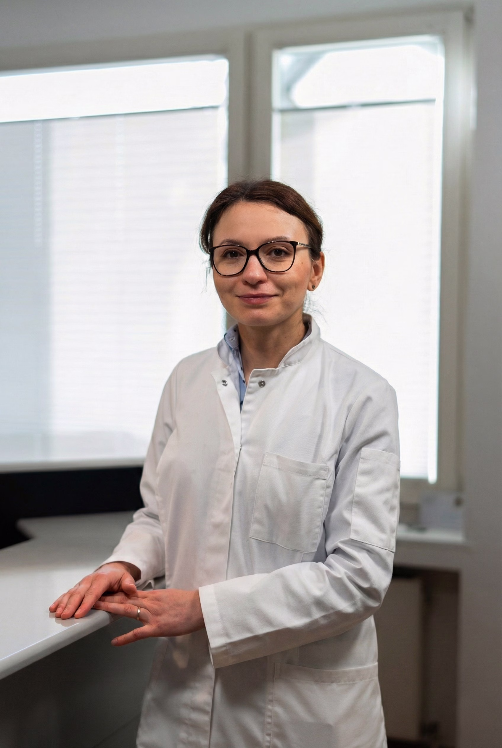 Porträt einer Hausärztin in Münster in weißem Arztkittel mit Brille