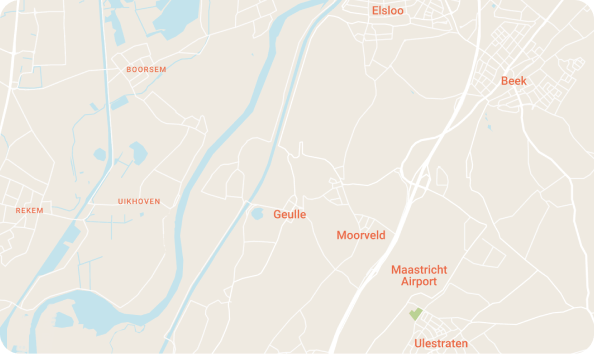 Person in a suit signing a business document on a clipboard at a desk with a laptop and glasses.