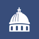 White silhouette of a domed building with a cross on top against a blue background.