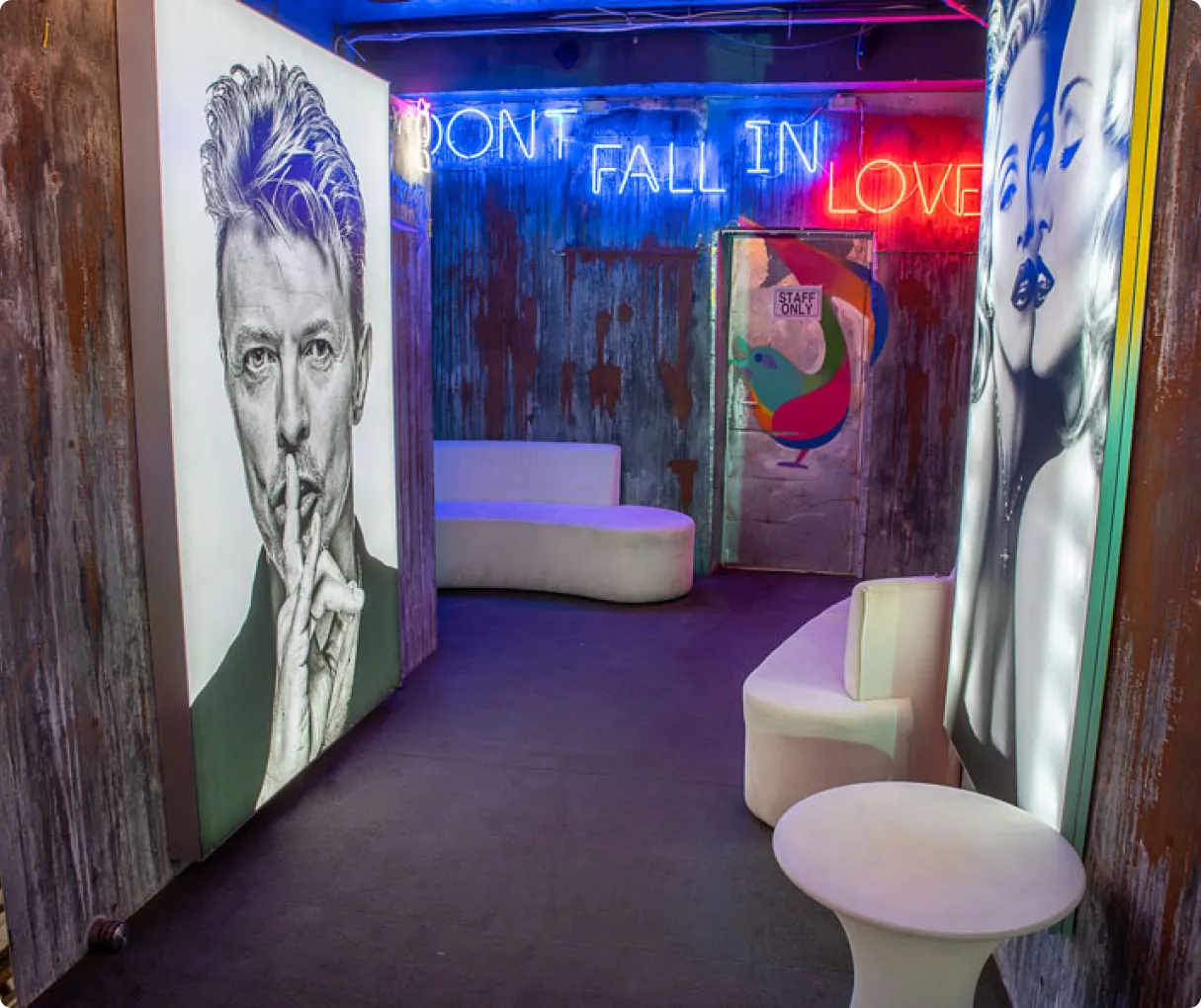 Colorfully lit wall display featuring multiple vinyl records around a central black screen in a modern music-themed room.