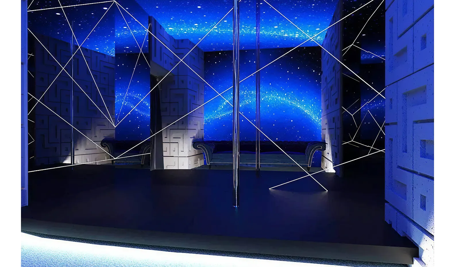 Modern office buildings reflected in a large water feature under a clear blue sky at sunset.