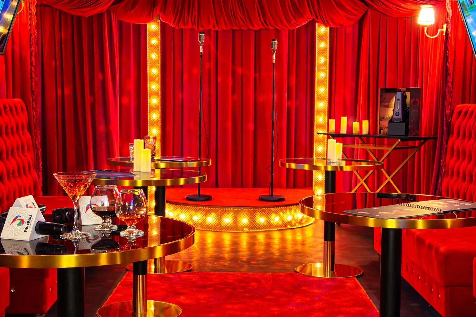 Art gallery hallway with black and white portraits on the walls and neon sign reading 'DON'T FALL IN LOVE' above a white couch.