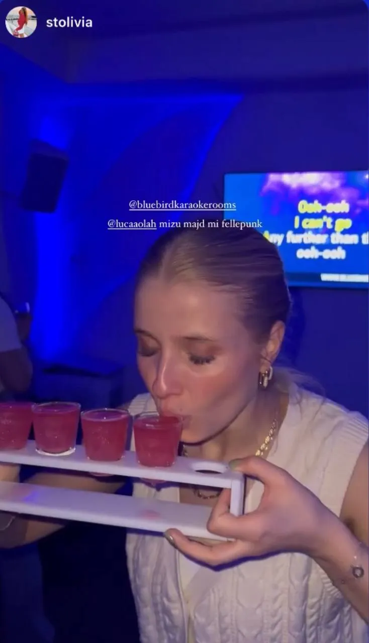Two young women singing and smiling closely together at a party with text saying 'Party never ends!!! We are open and waiting for you tonight, guys' and a heart emoji.
