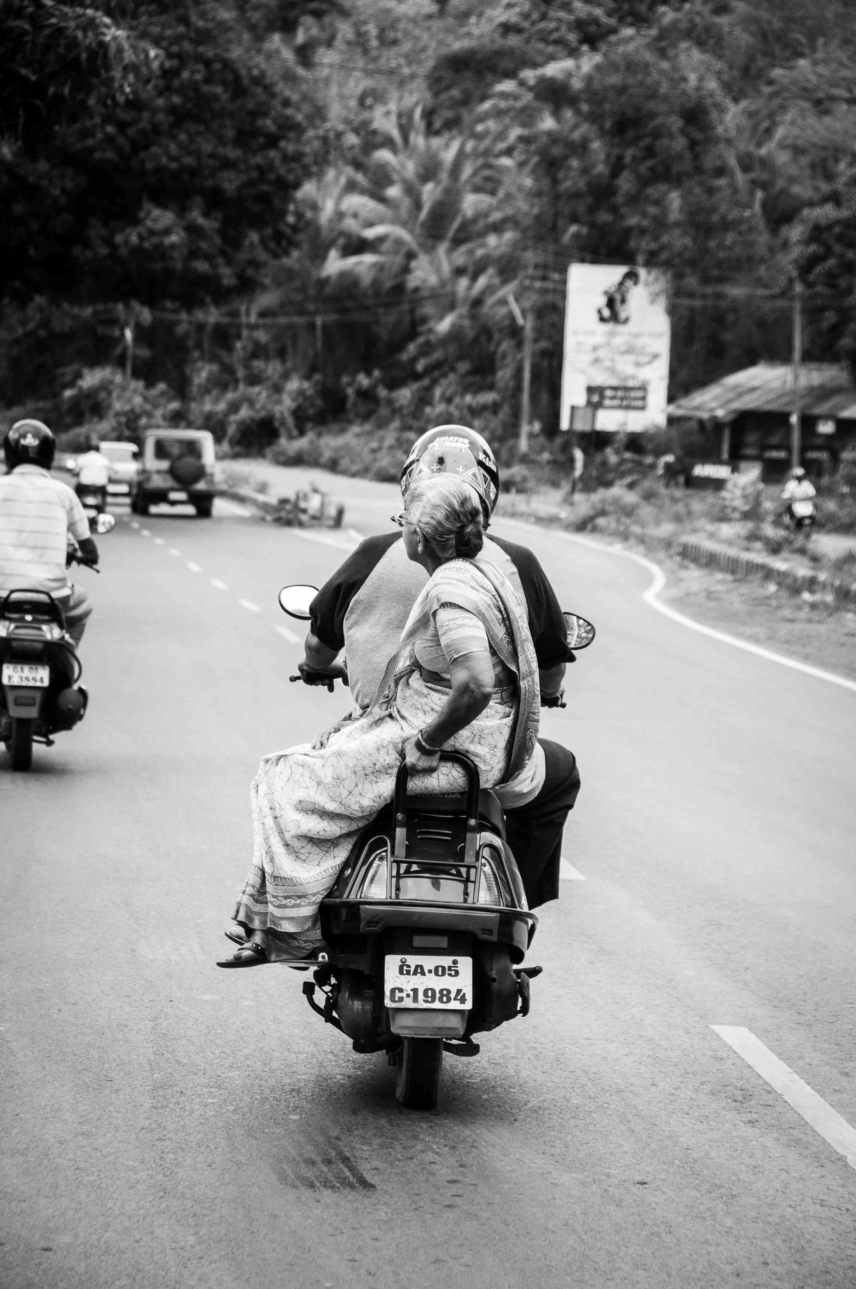 Frau sitzt seitlich auf Motorroller