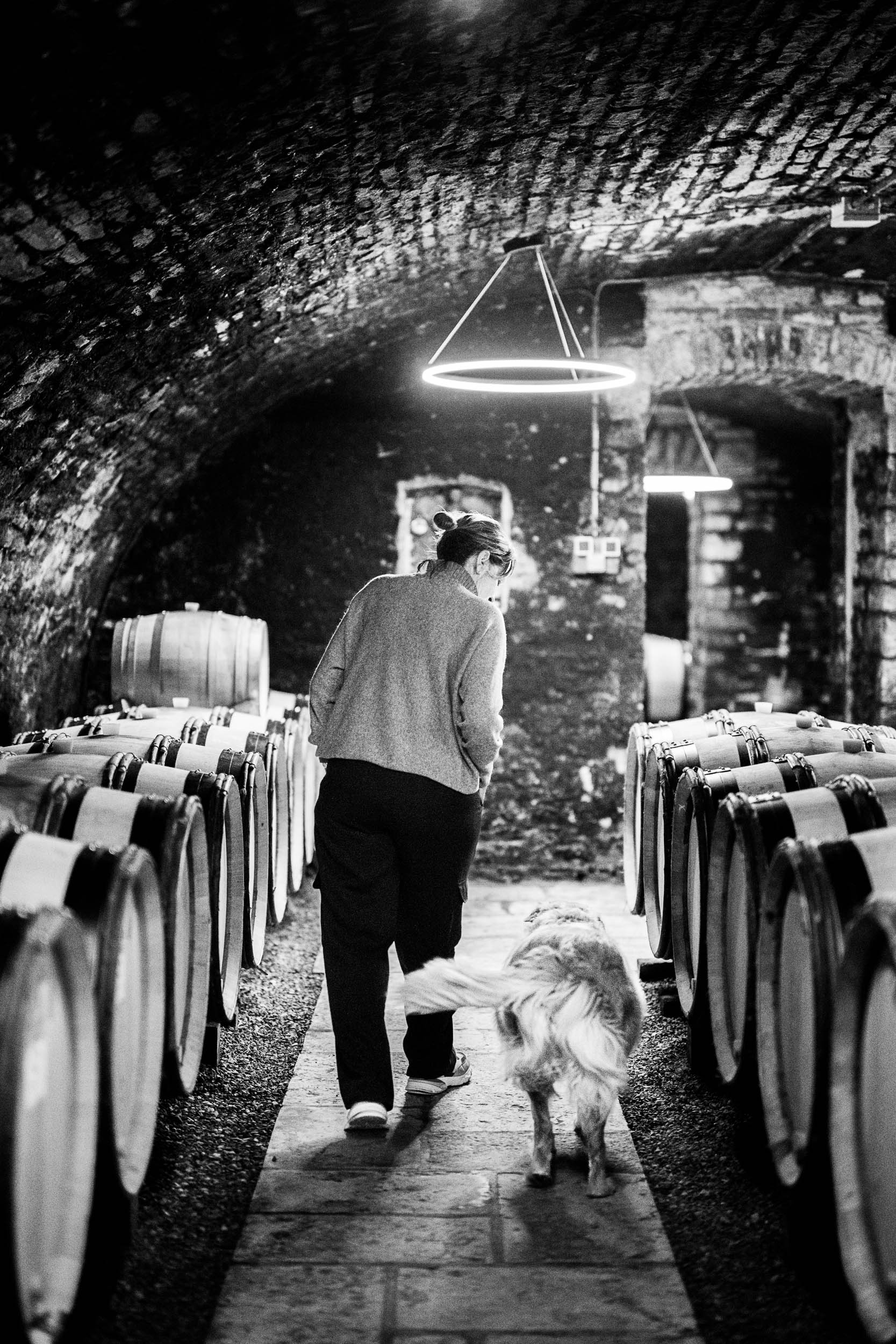 Winzerin mit ihrem Hund im Weinkeller